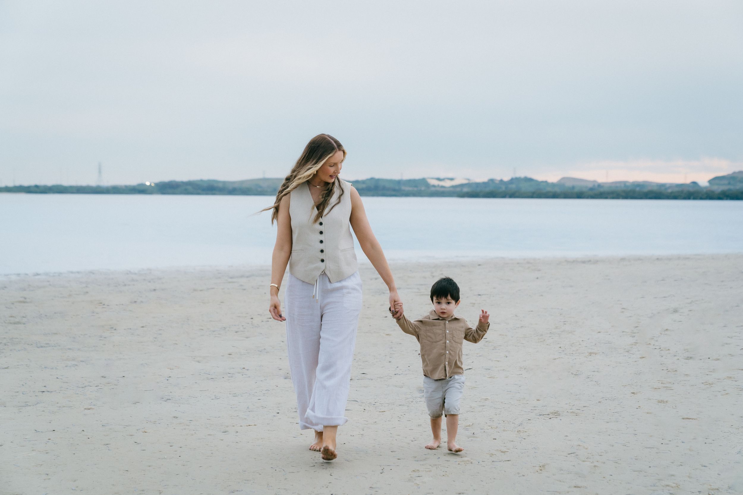 Toddler holding hands with mother during a photo shoot session in Sydney.