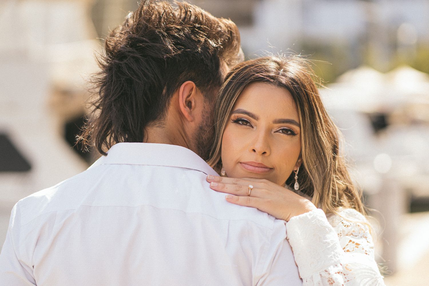 A romantic moment captured in soft sunlight with white lace details.