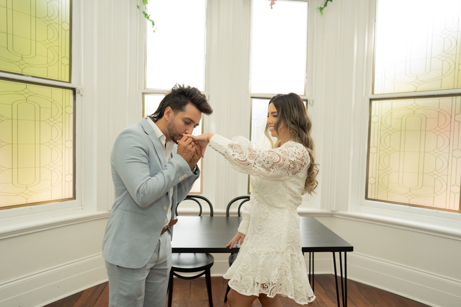 An emotional moment between a couple in a sunlit room with vintage decor.