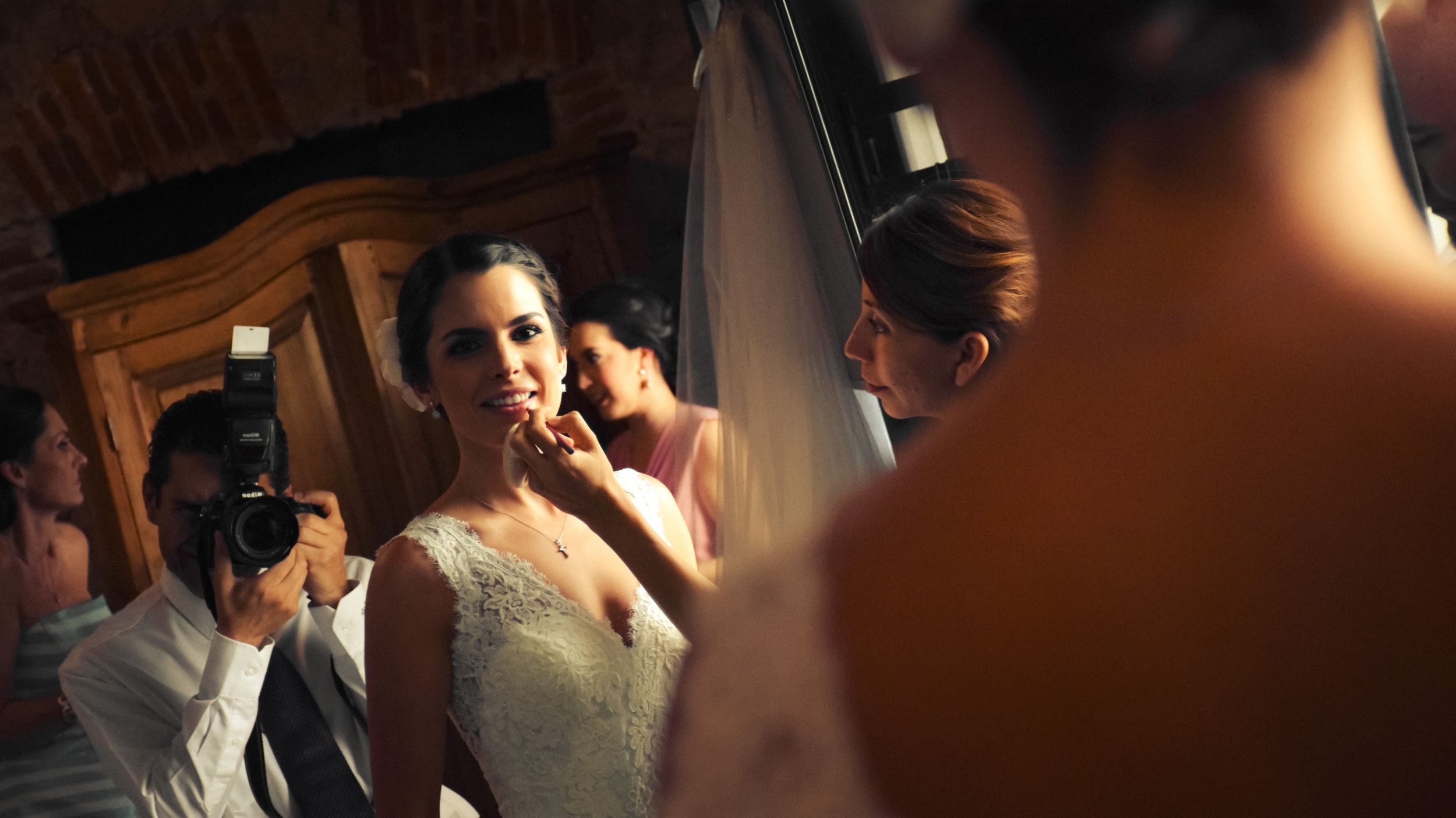 Wedding preparation moment captured in mirror reflection with dramatic lighting.