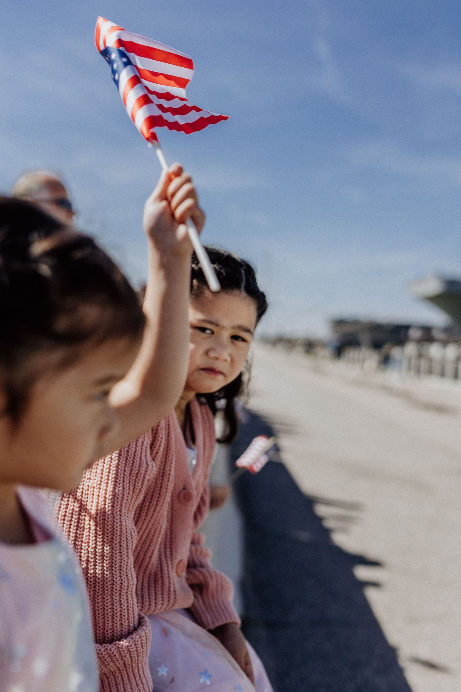 girl looking into the camera waiting at military homecoming waving american flag military photographer norfolk, virginia