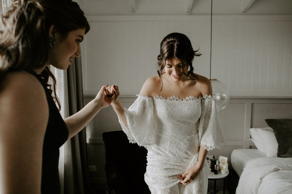 Getting ready scene with a bride in an off-shoulder wedding dress.