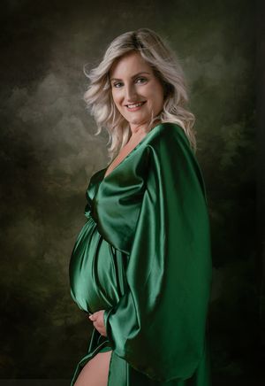 Prachtige zwangere dame in groene zwangerschapsjurk. Fine-art portret zwangerschapsshoot