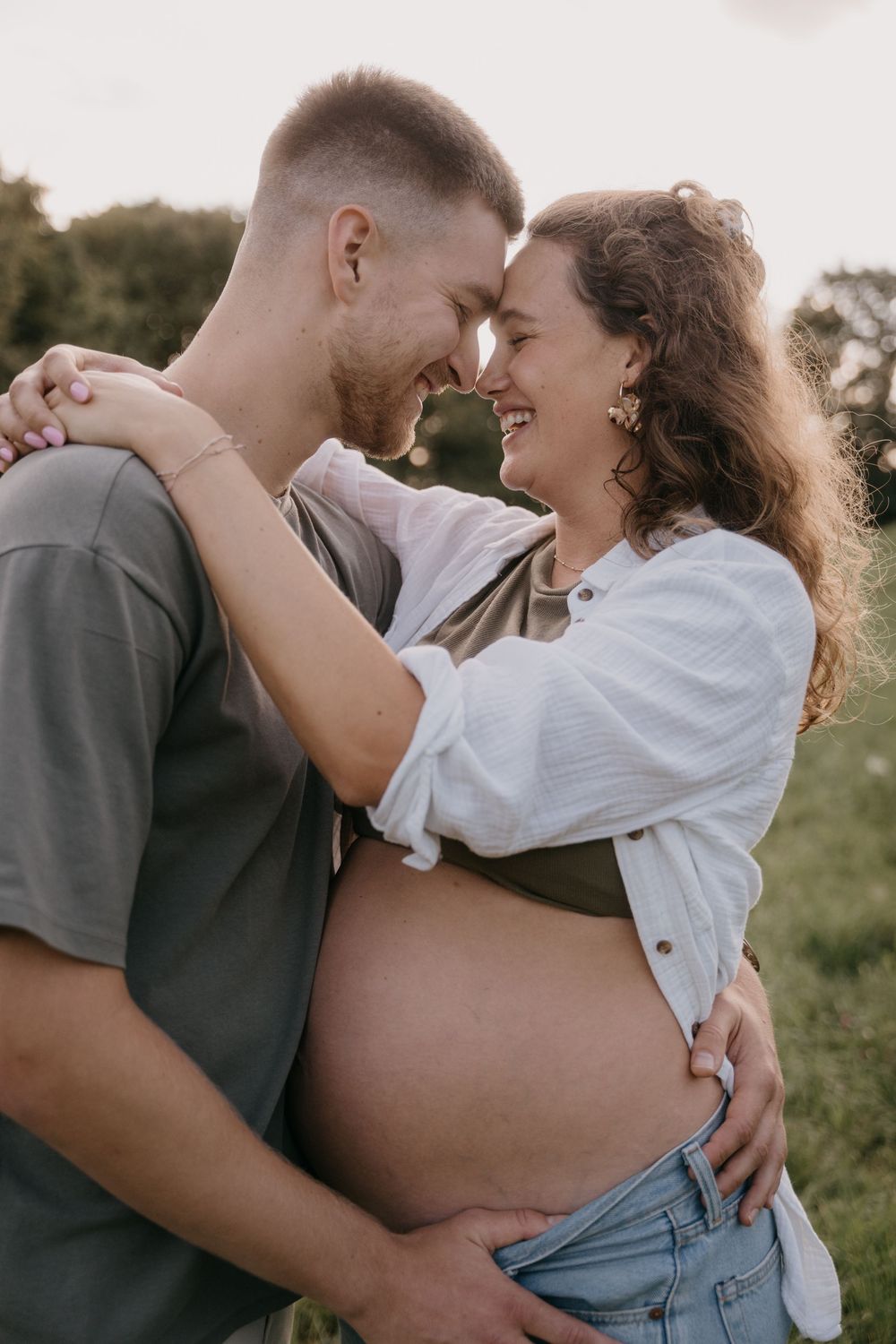 Intimate couple embraces passionately in romantic outdoor photoshoot with natural lighting and soft focus.