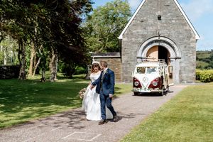 A split collage of romantic moments outside a stone church with a vintage Volkswagen van in the background.