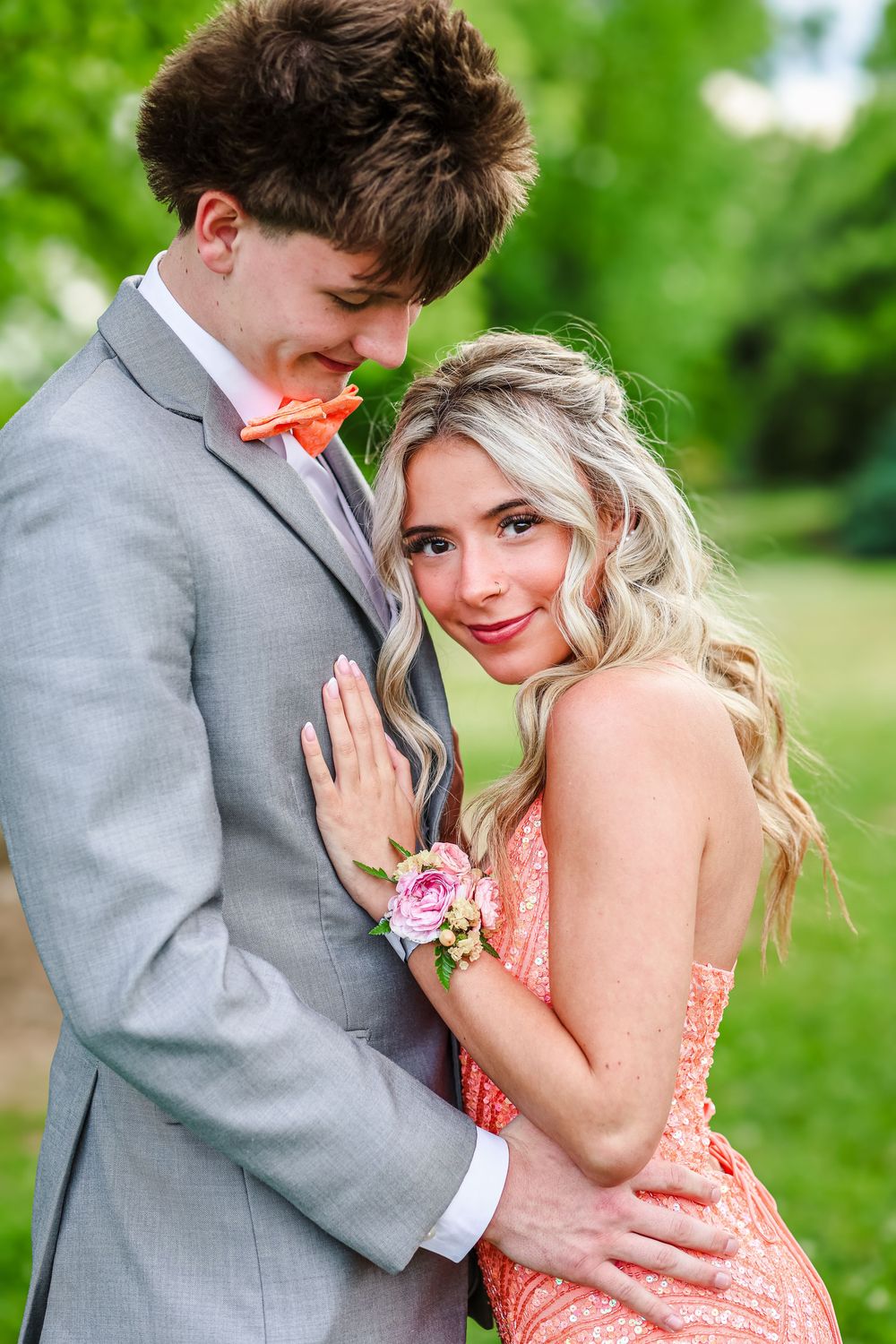 A prom couple holding each other while she looks at the camera.