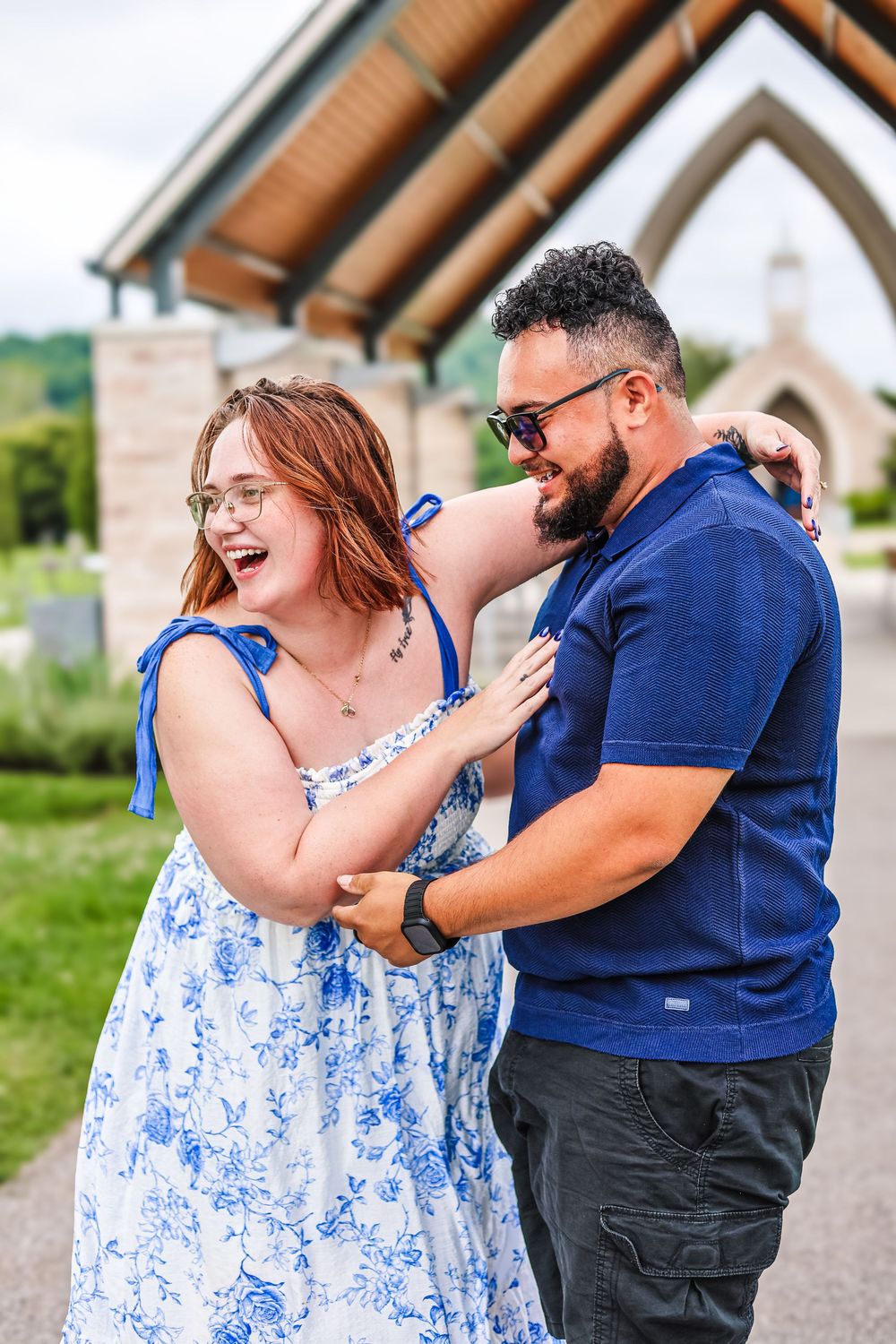 A candid image of a couple laughing holding each other during an engagement session.