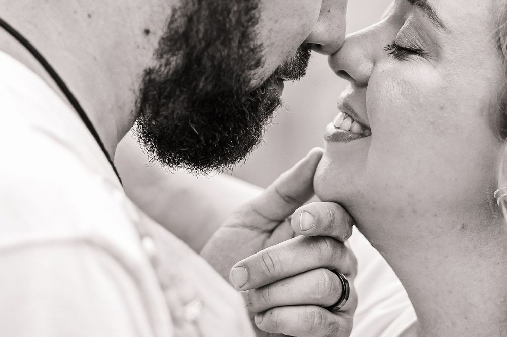 A close-up black and white image of a couple about to kiss.