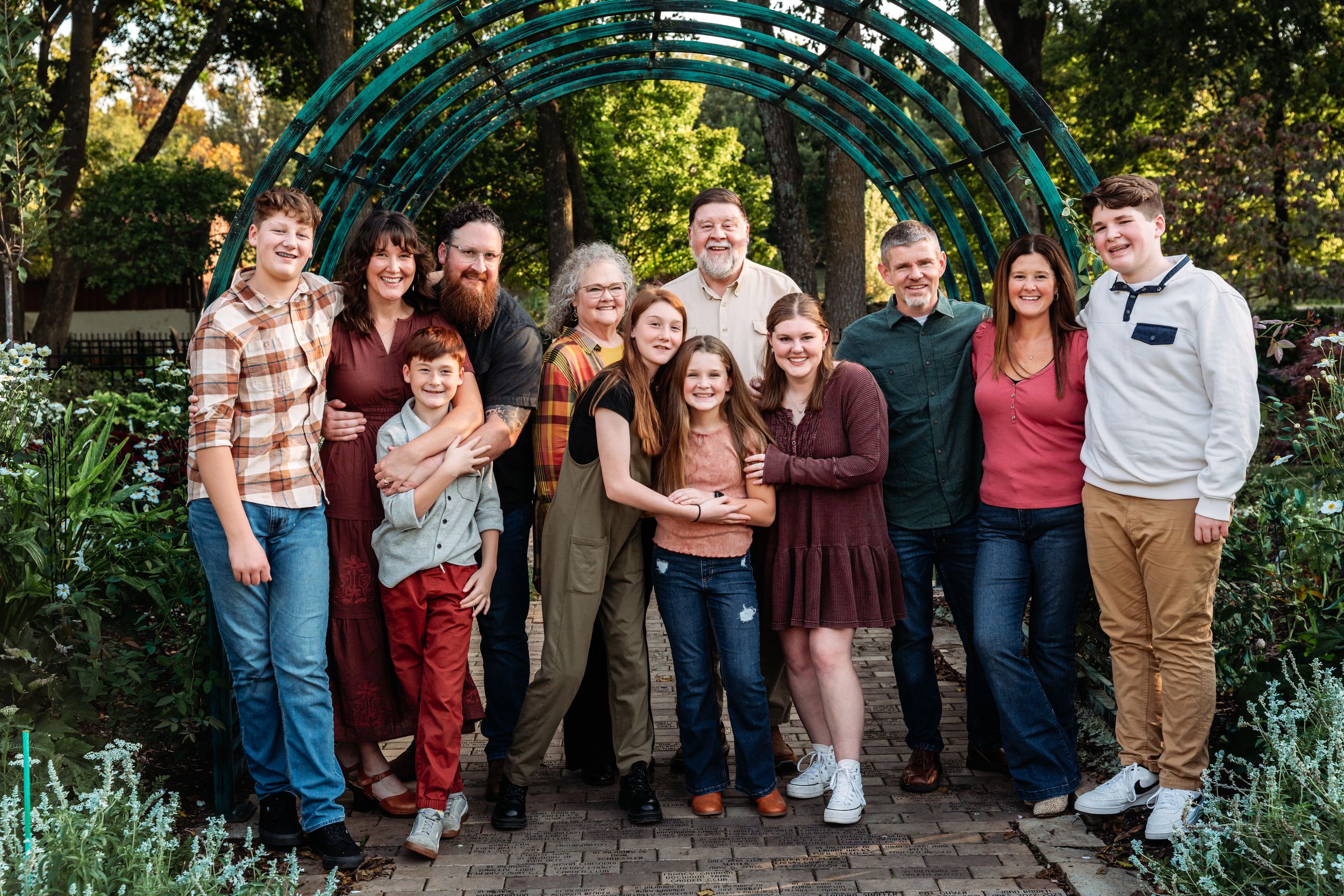 Large group of people gathered outdoors in casual attire for a family photo session.
