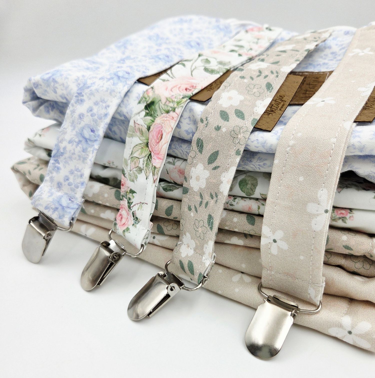 Collection of vintage-style pacifier clips with floral and pastel patterns.