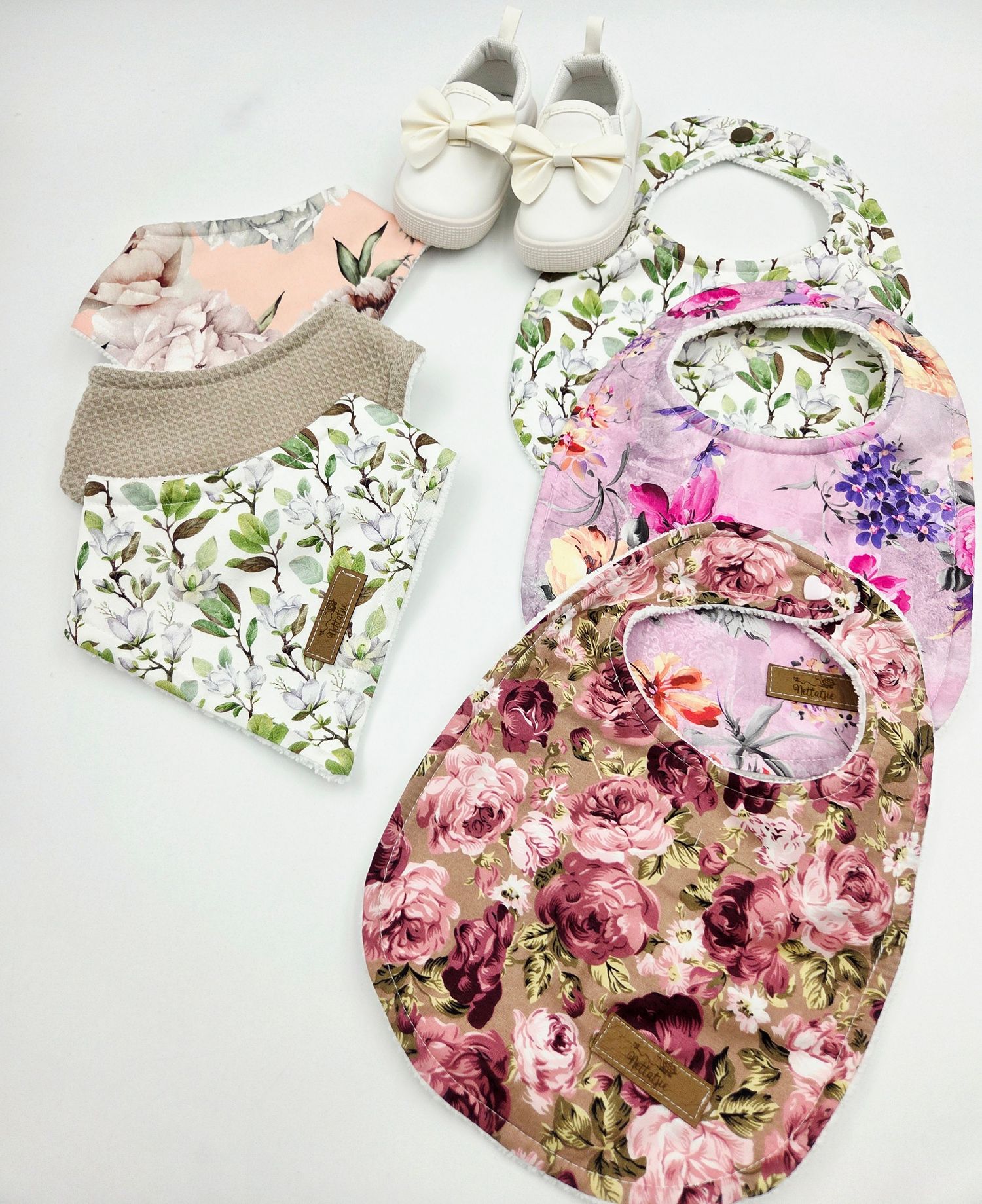 Baby clothing set featuring floral prints in pink and white with matching accessories.