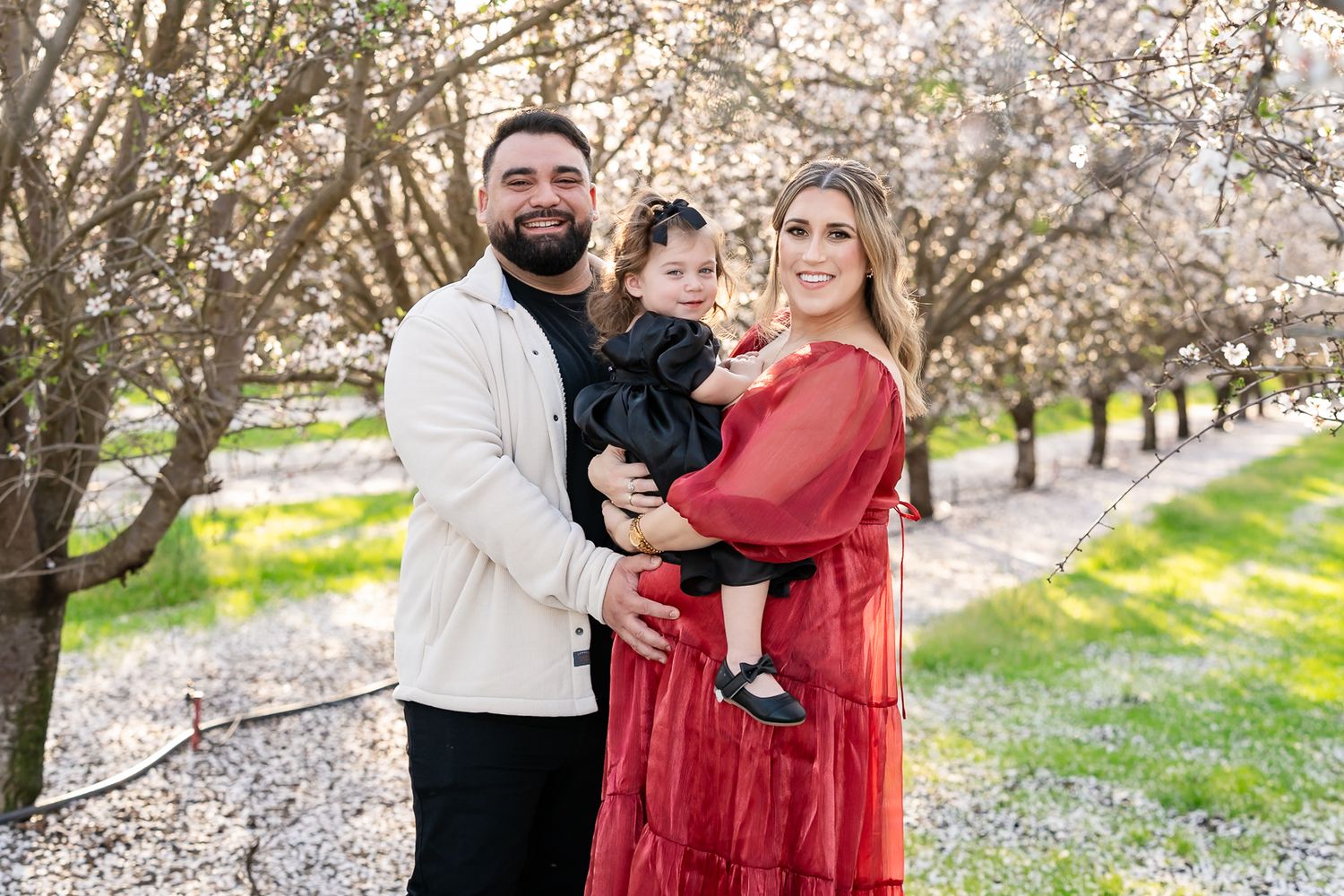Family portraits in Tracy, CA almond blossoms. Warm and vibrant outdoor photography capturing love and joy.