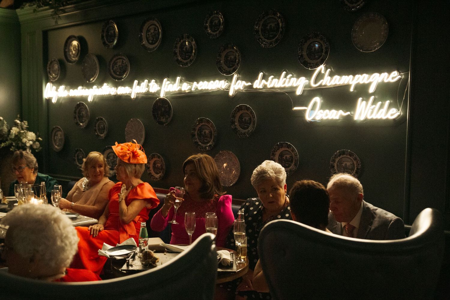 Elegant dinner reception with neon sign and moody lighting.