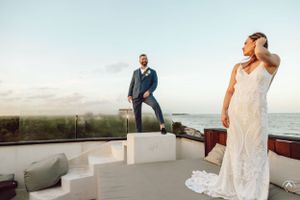 Couple poses for romantic sunset photos on coastal wedding venue balcony, Papaya Playa Tulum Wedding.