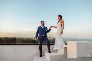 Couple takes romantic photos on white coastal terrace during destination wedding, Papaya Playa Tulum Wedding.