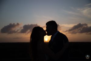 Silhouettes against a dramatic sunset sky during an outdoor wedding ceremony, Papaya Playa Tulum Wedding.