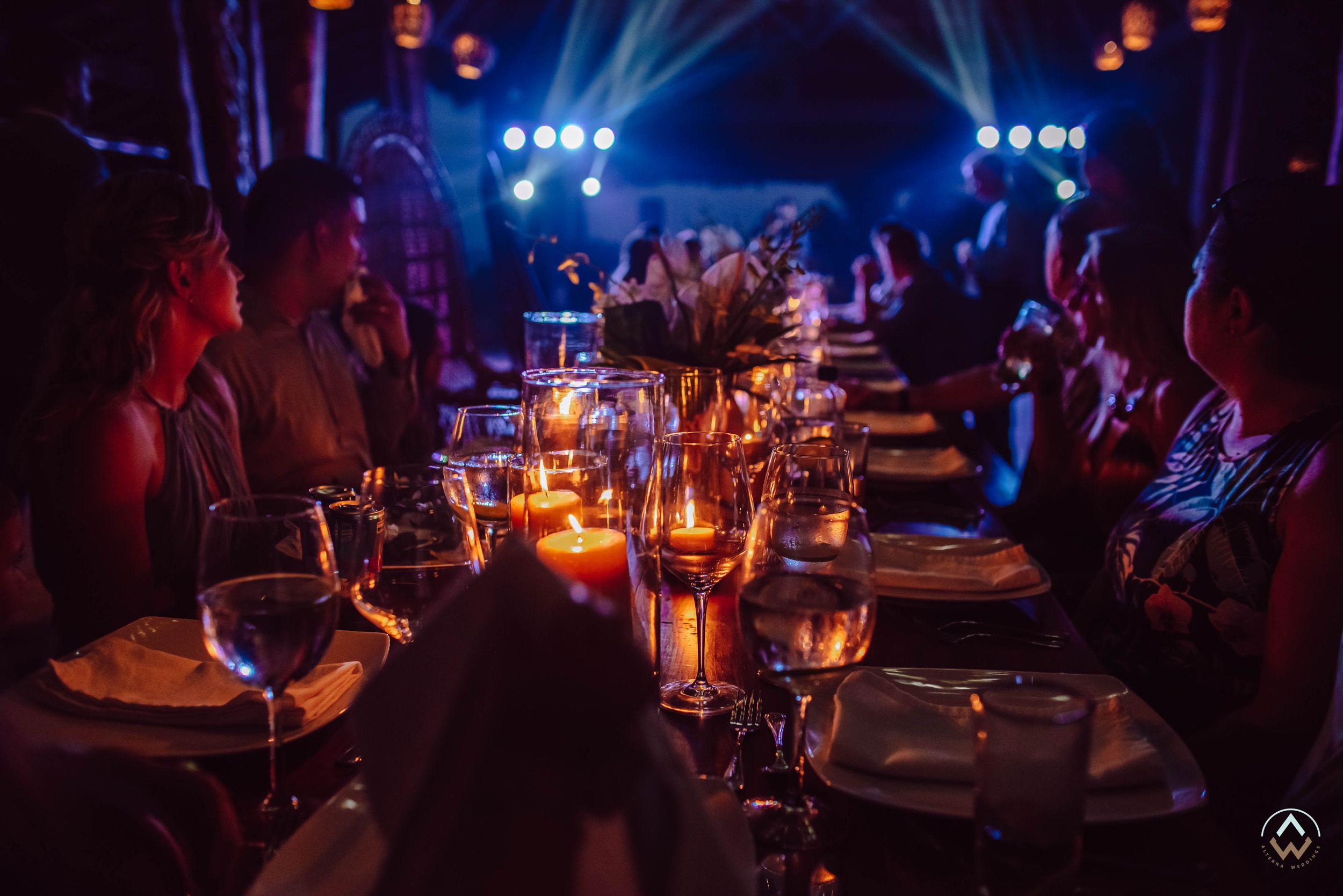 Moody wedding reception venue illuminated with blue lighting and hanging lanterns, Papaya Playa Tulum Wedding.