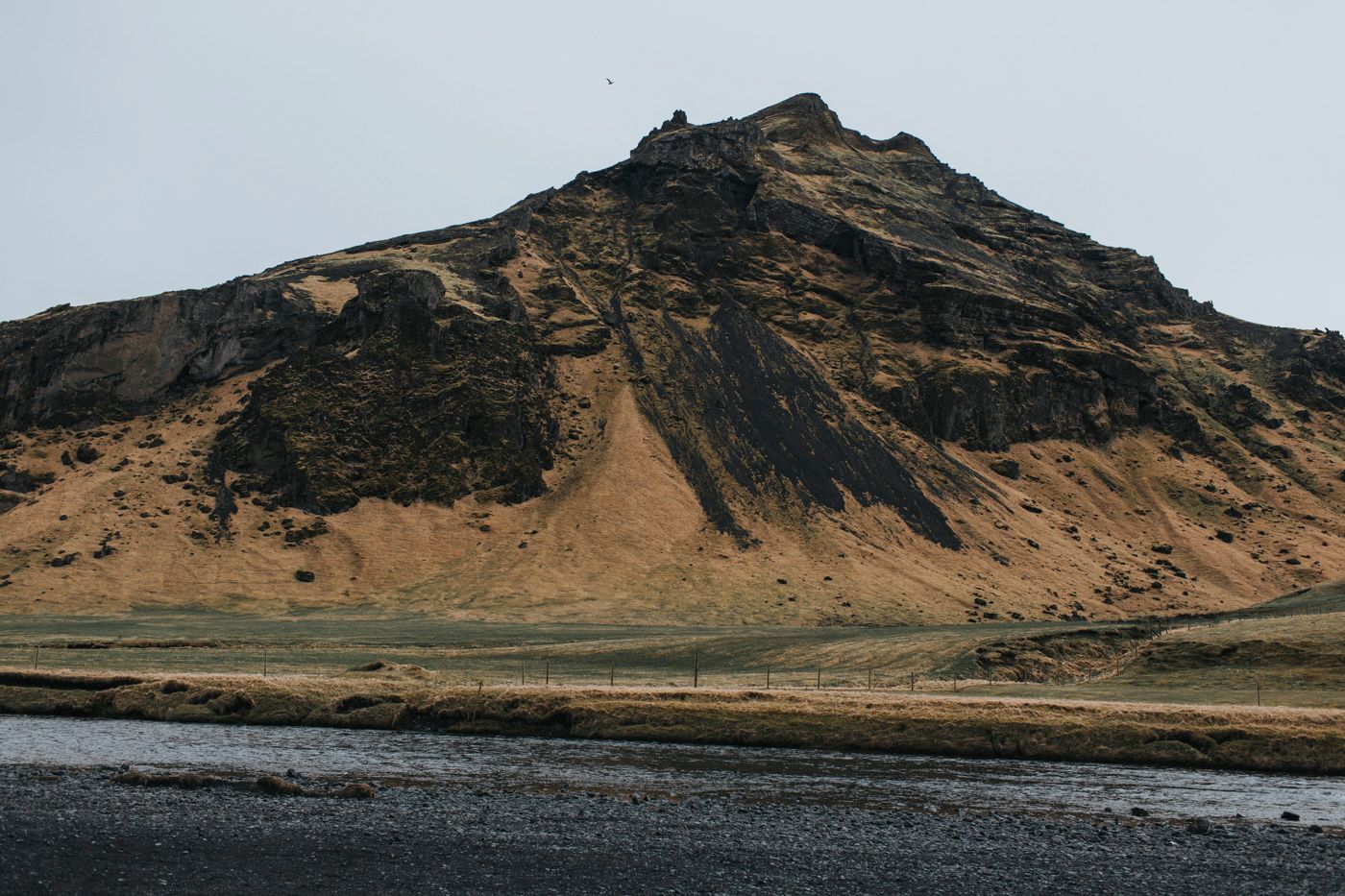 A dramatic mountain landscape with black sand beach in Iceland.