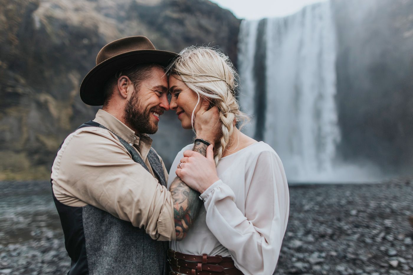 An intimate moment between newlyweds near a cascading waterfall.
