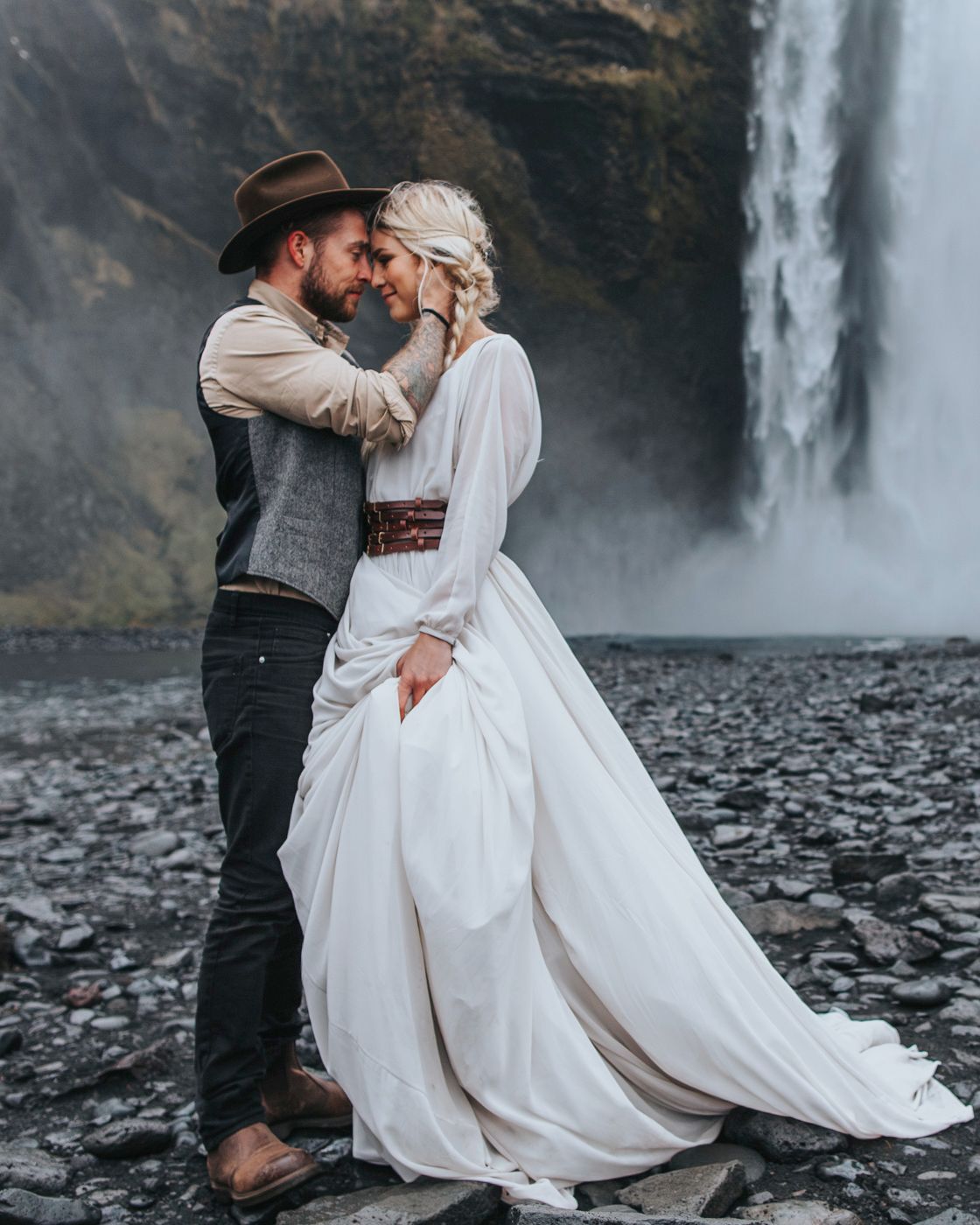 A romantic wedding portrait with a majestic waterfall backdrop in Iceland.