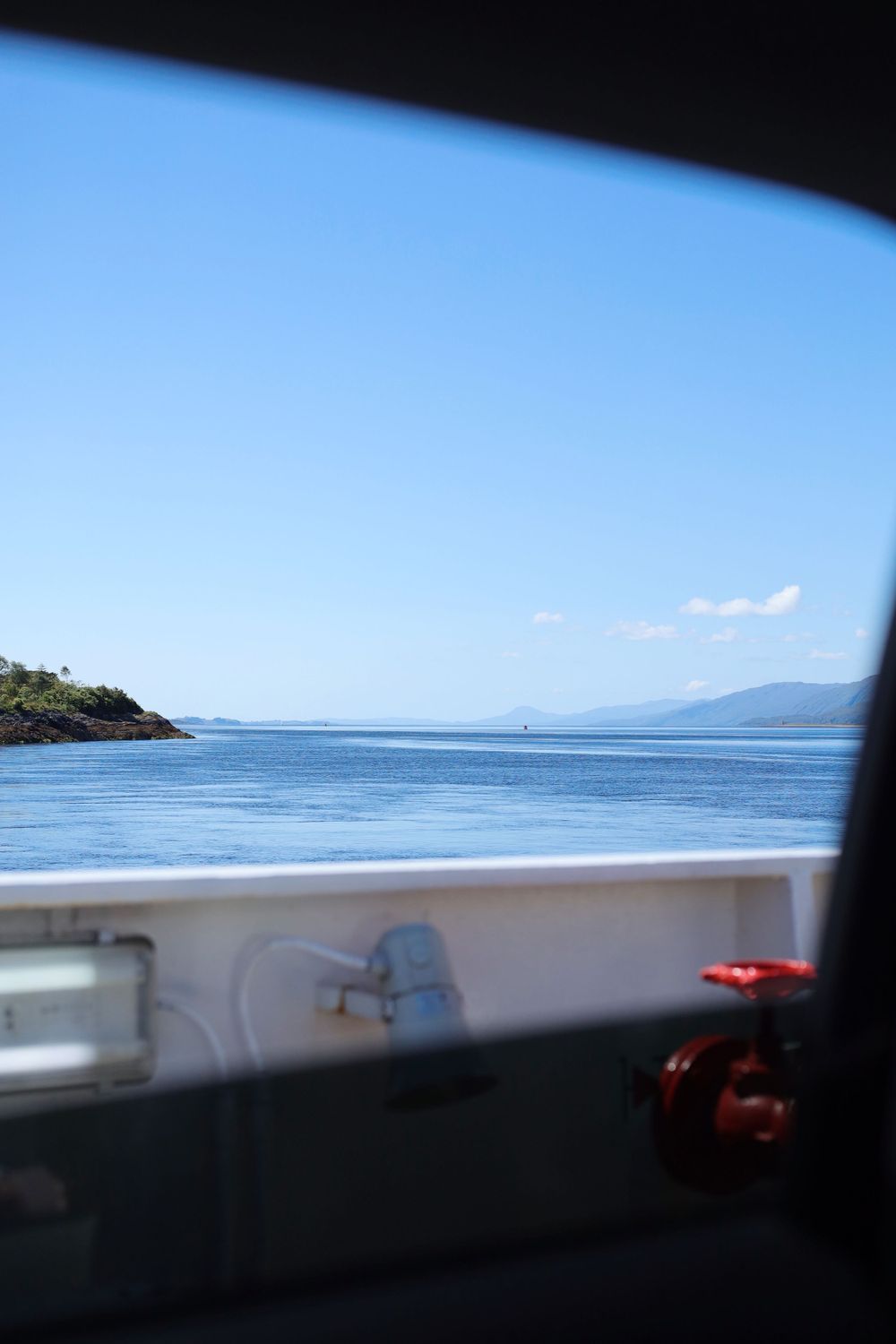 Ocean view from a boat showing blue waters and distant coastline.