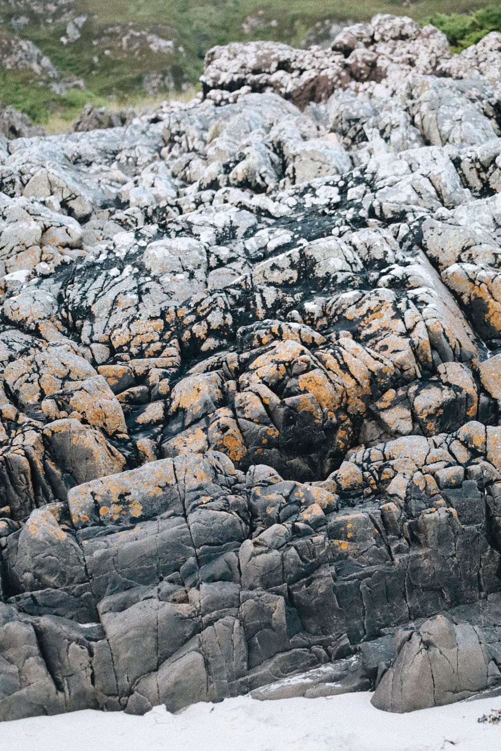 Rugged rocky coastline with textured granite formations and natural patterns.