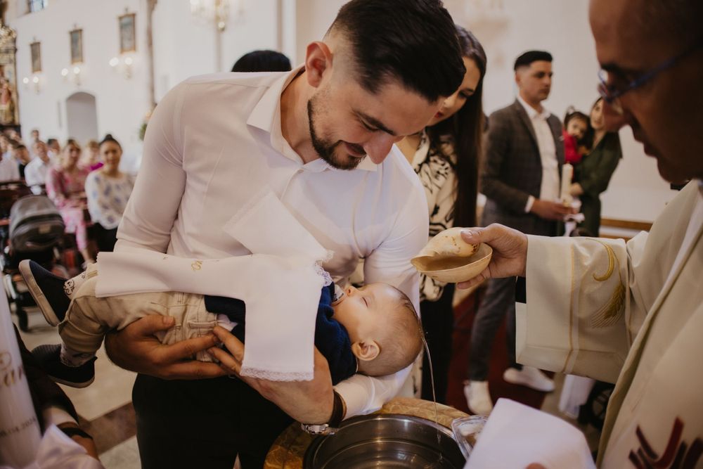 Baptism ritual being performed at a traditional church ceremony.