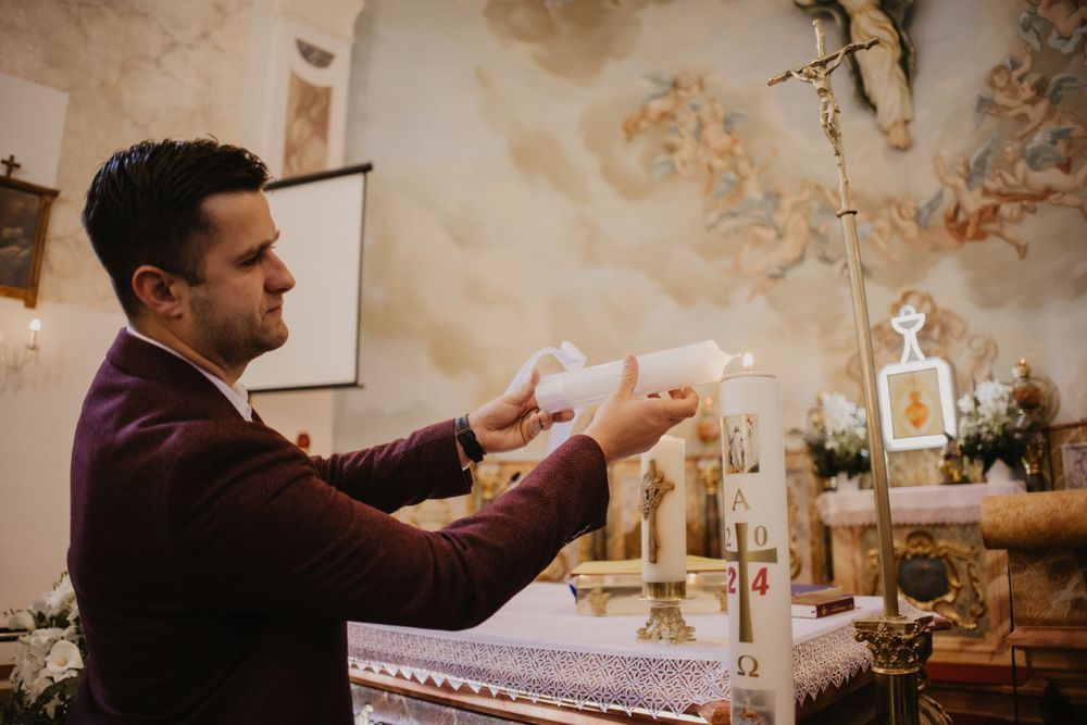 A priest performing a religious ceremony at an ornate altar with candles and religious symbols.