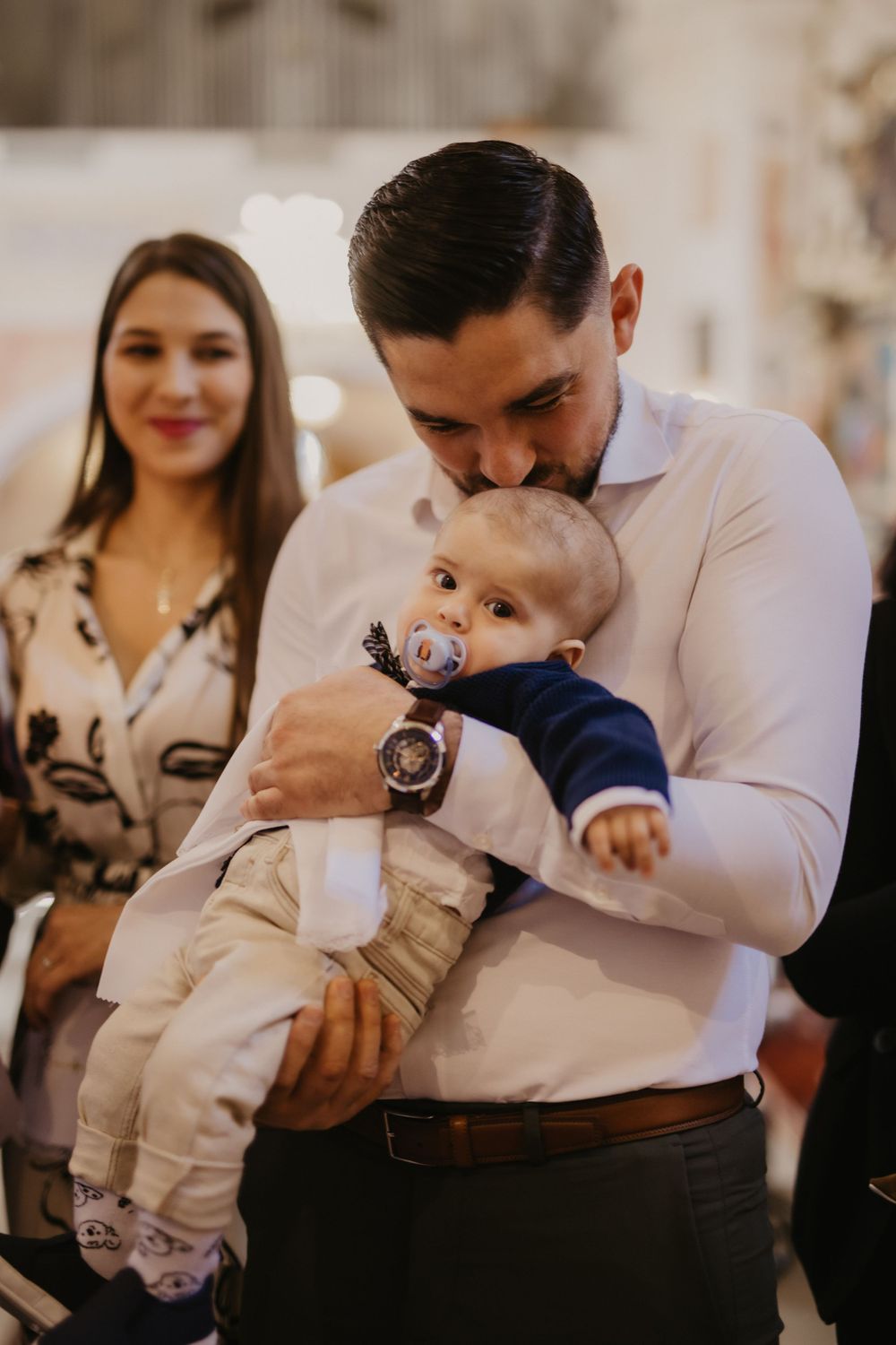 An intimate family moment during a baptism ceremony in church.
