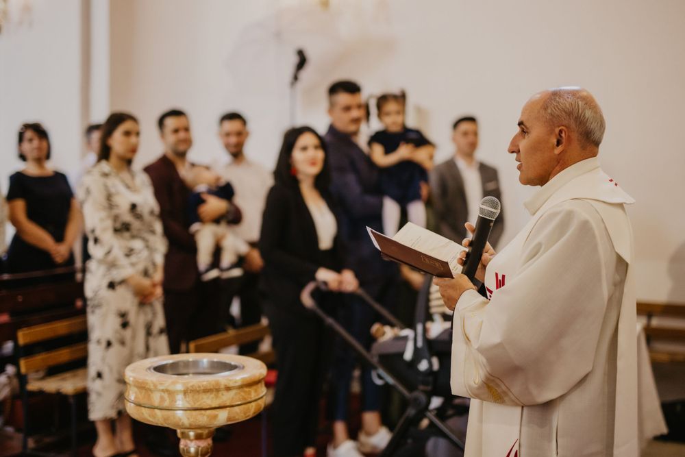 Religious ceremony takes place in a church with attendees gathered around.