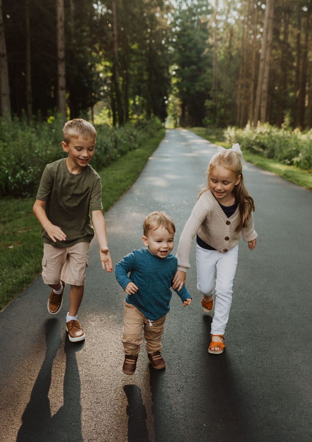 Active family playing and running together on a paved forest trail.