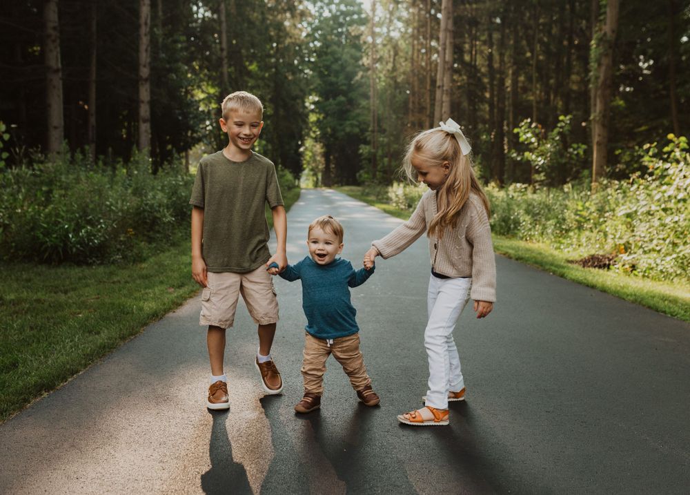 Family members running and playing on a shaded forest path.