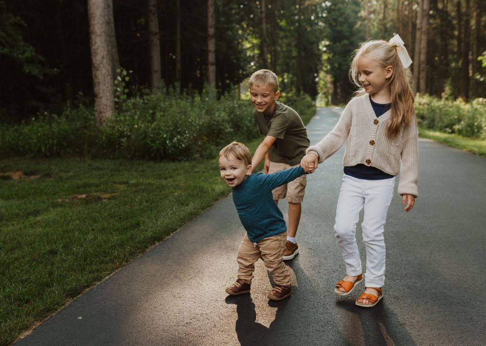 Dynamic family photo session showing movement and joy on a forest trail.