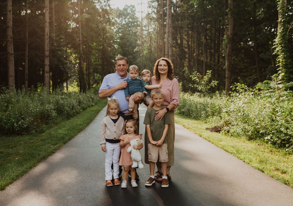 Family members walking together on scenic woodland trail.