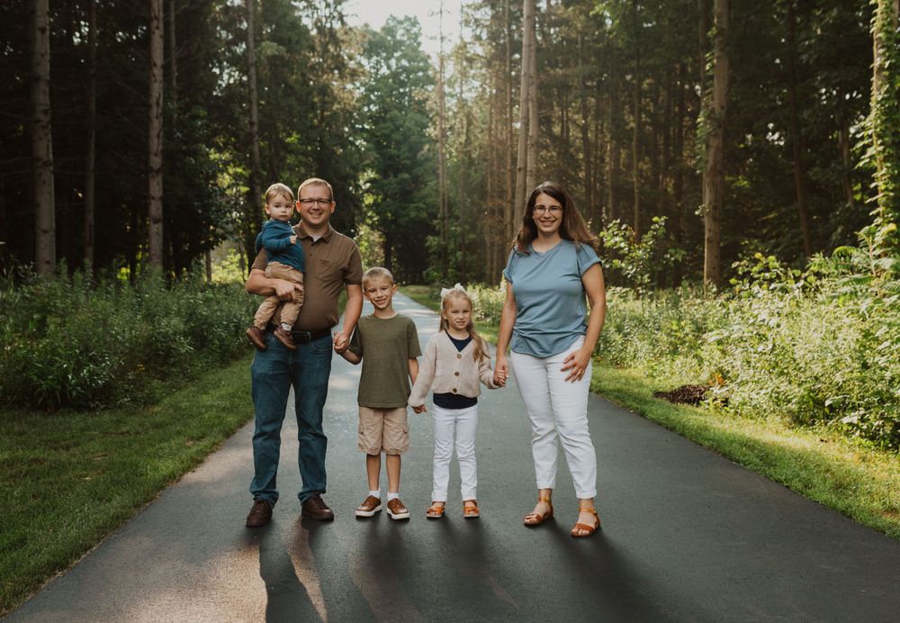 Candid family moments captured on a forest path during summer evening.