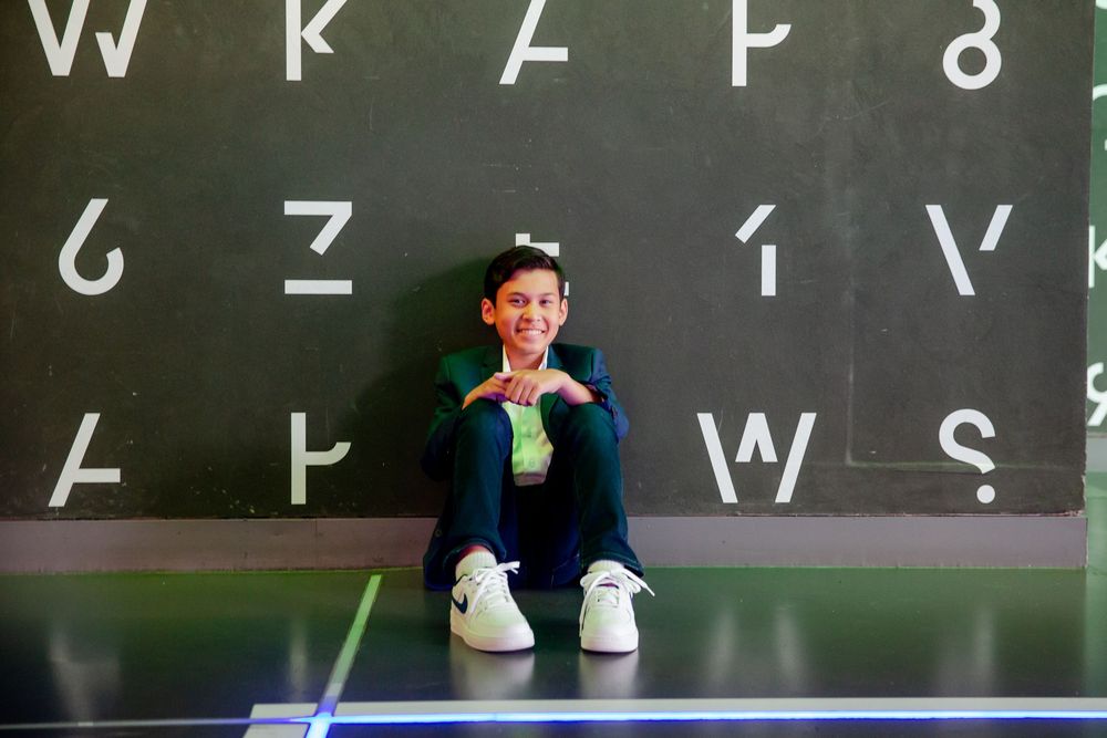 A golfer lines up a putt on a green with a chalkboard and numbers visible in the background.