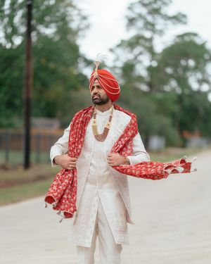 A Sikh groom in traditional Indian attire strikes stylish poses in a series of outdoor wedding photos.