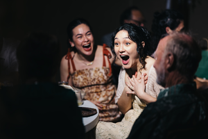 Candid moment of joyful laughter and surprised expressions during an evening celebration or gathering.