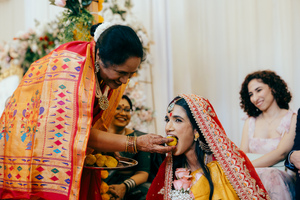 Colorful Indian wedding ceremony in Houston with traditional orange and red attire during intimate celebration.