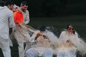 People splash and throw water during an outdoor Haldi event of a Telugu wedding in Dallas, TX.