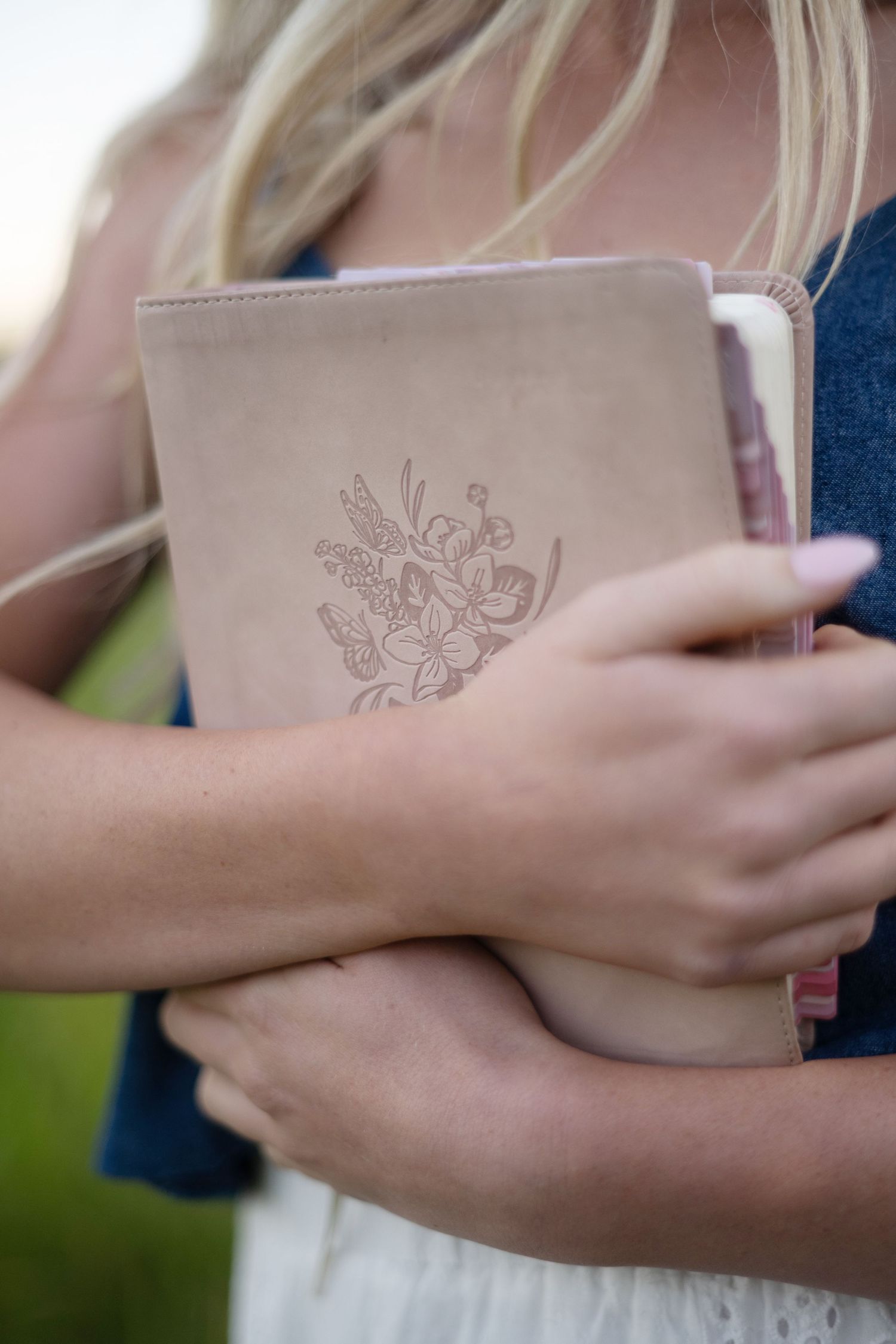 A series of outdoor senior portraits featuring a brown book, white top, and floral skirt against a soft natural background.