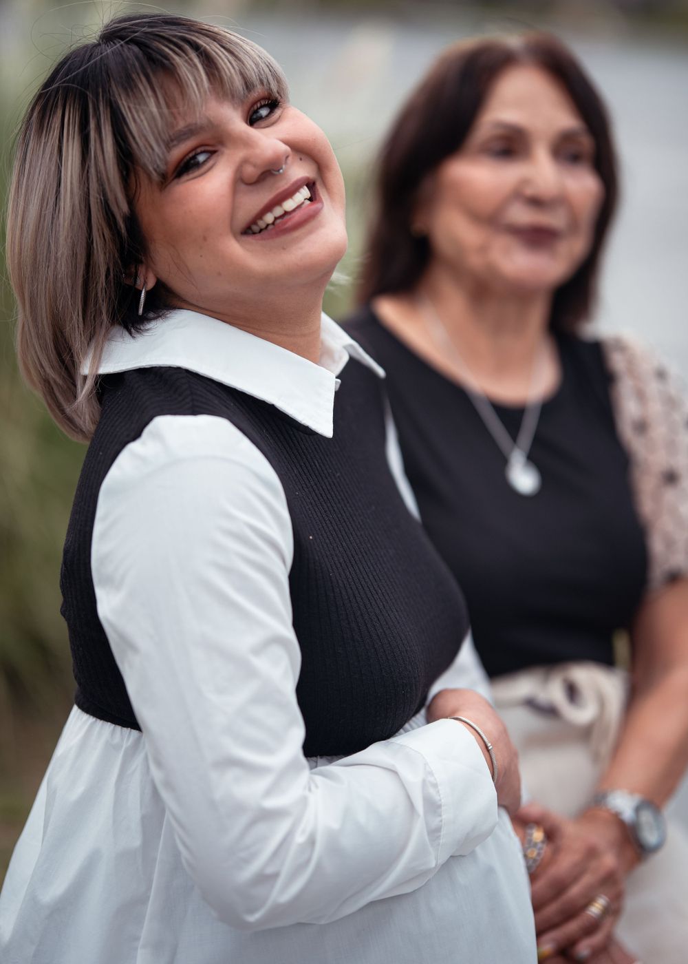 Two people share a candid moment outdoors with natural lighting.
