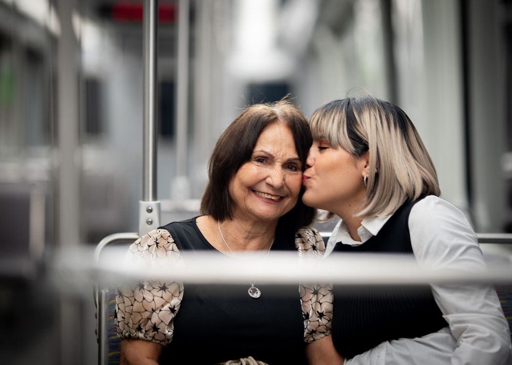 Two people share an intimate moment in an urban setting with selective focus.