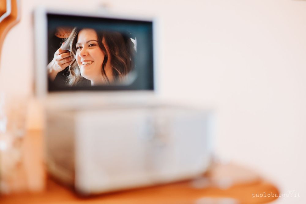 Blurred reflection in mirror showing wedding preparation moment.