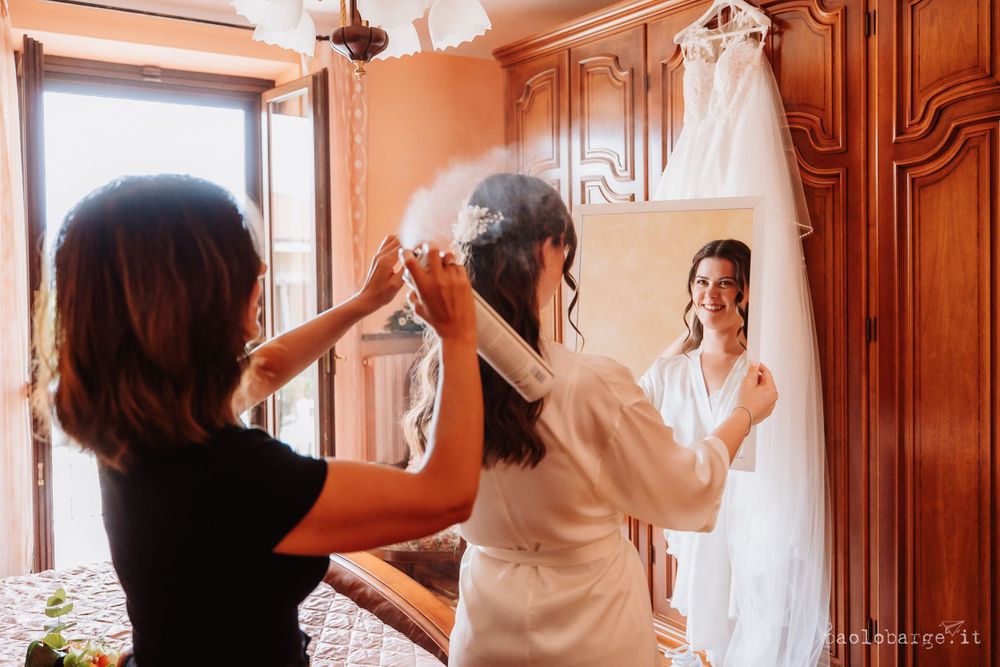 Wedding preparation scene showing a wedding dress being fitted in a warm-toned dressing room.