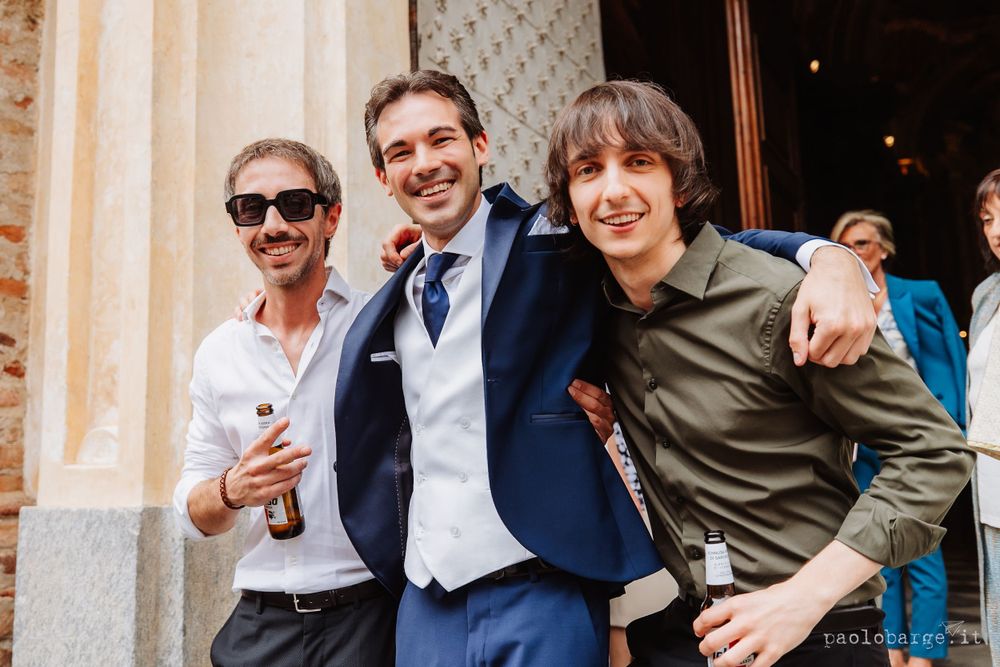 Three friends pose together outside celebrating at a wedding event.