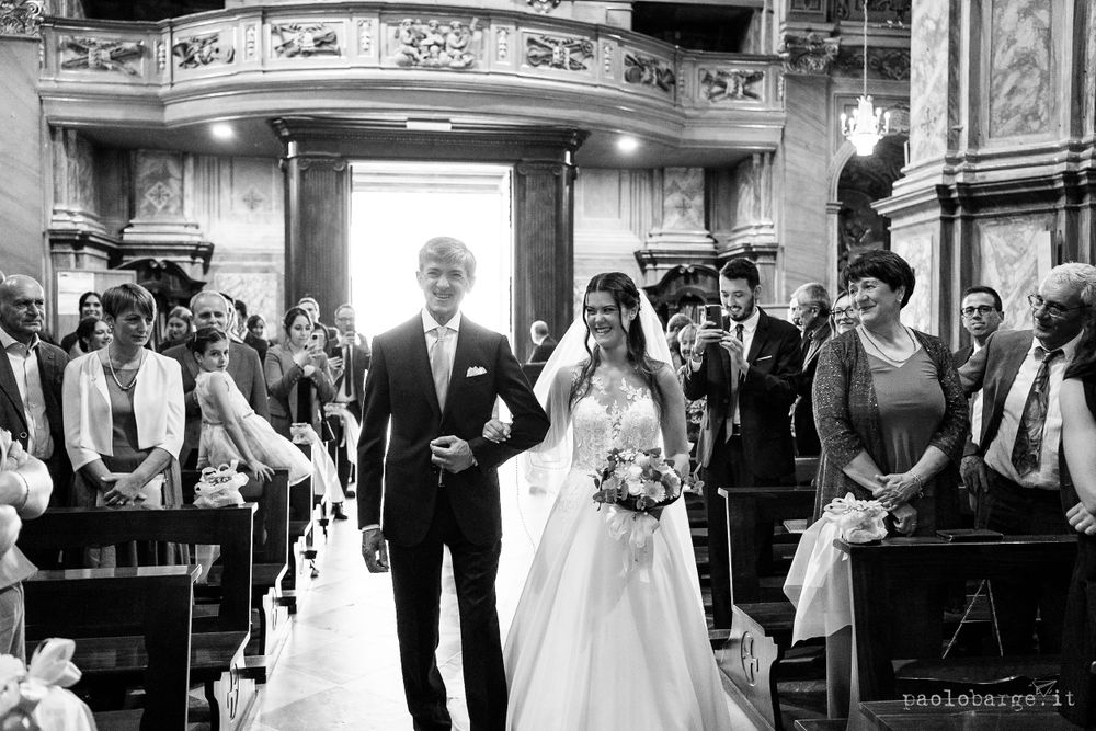 Black and white photograph of a wedding ceremony in a grand cathedral with gathered guests.