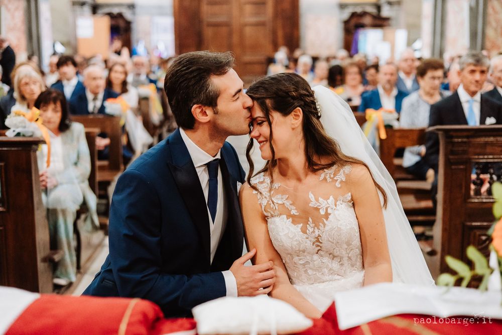 Intimate moment during church wedding ceremony with couple at decorated altar.