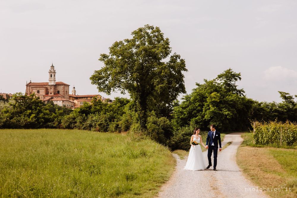 Couple walking on countryside path with church on hilltop in background.