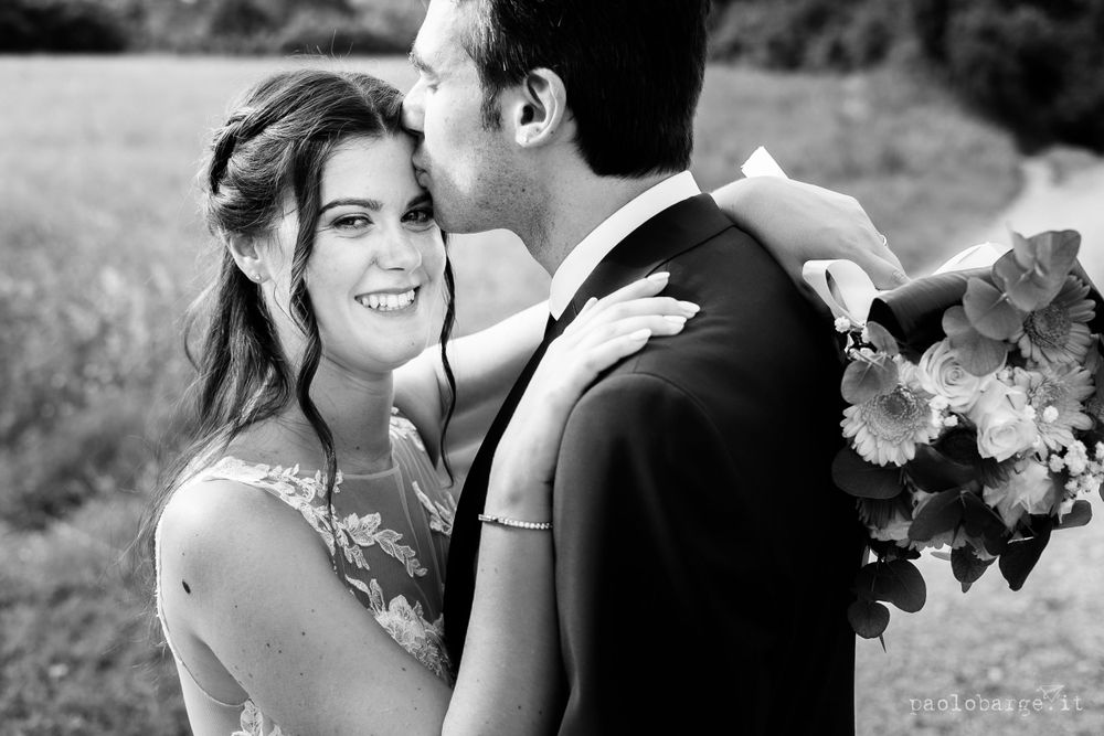 Romantic black and white portrait of newlyweds in outdoor setting.